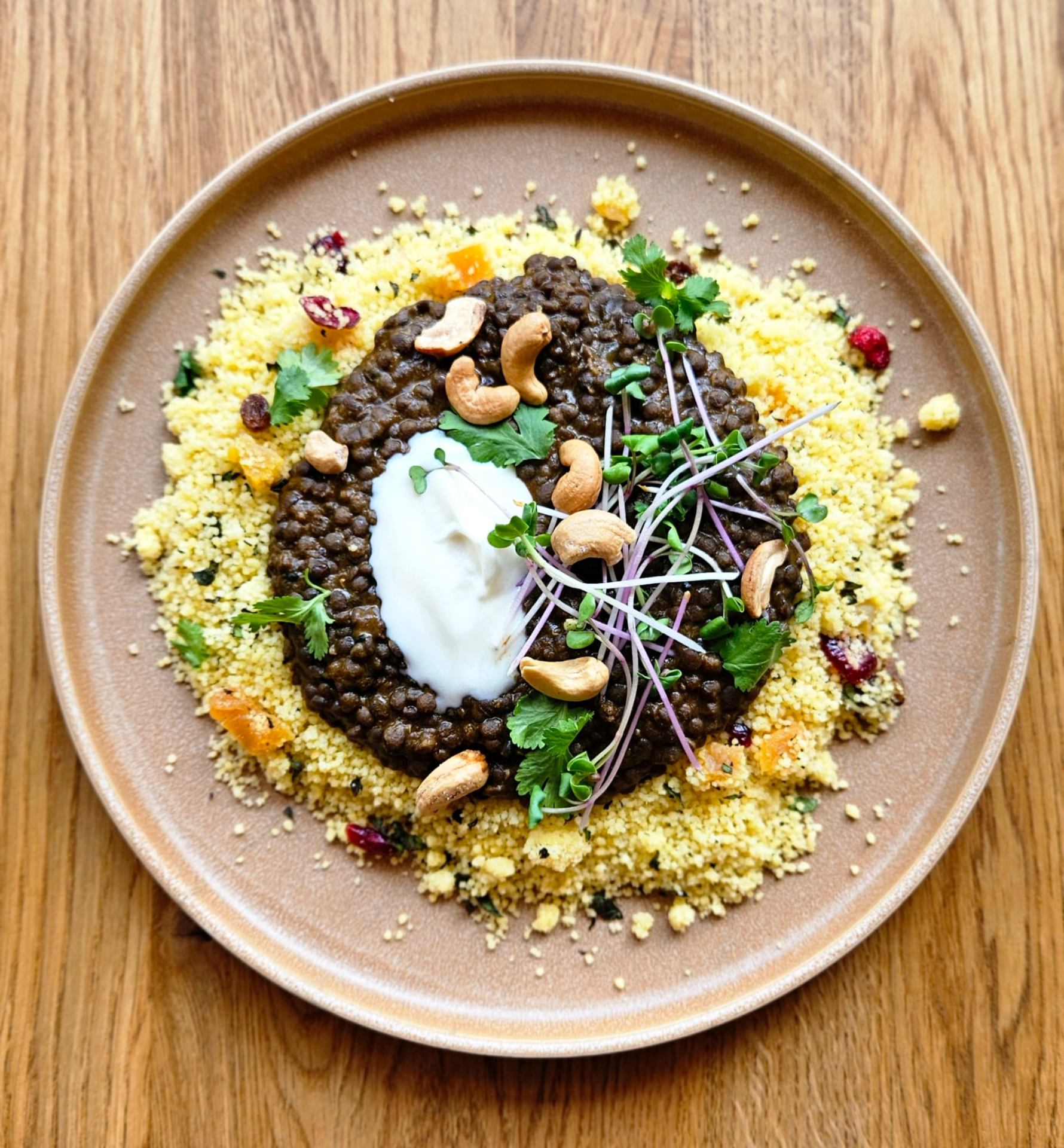 A plate of lentils on herbed couscous with cashews, microgreens and yoghurt, by chef Milica Fisher