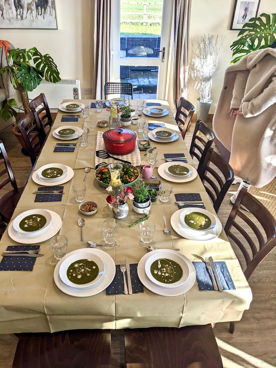 Long shared table set with green soup and plant-based dishes at The Happy Body Project day
