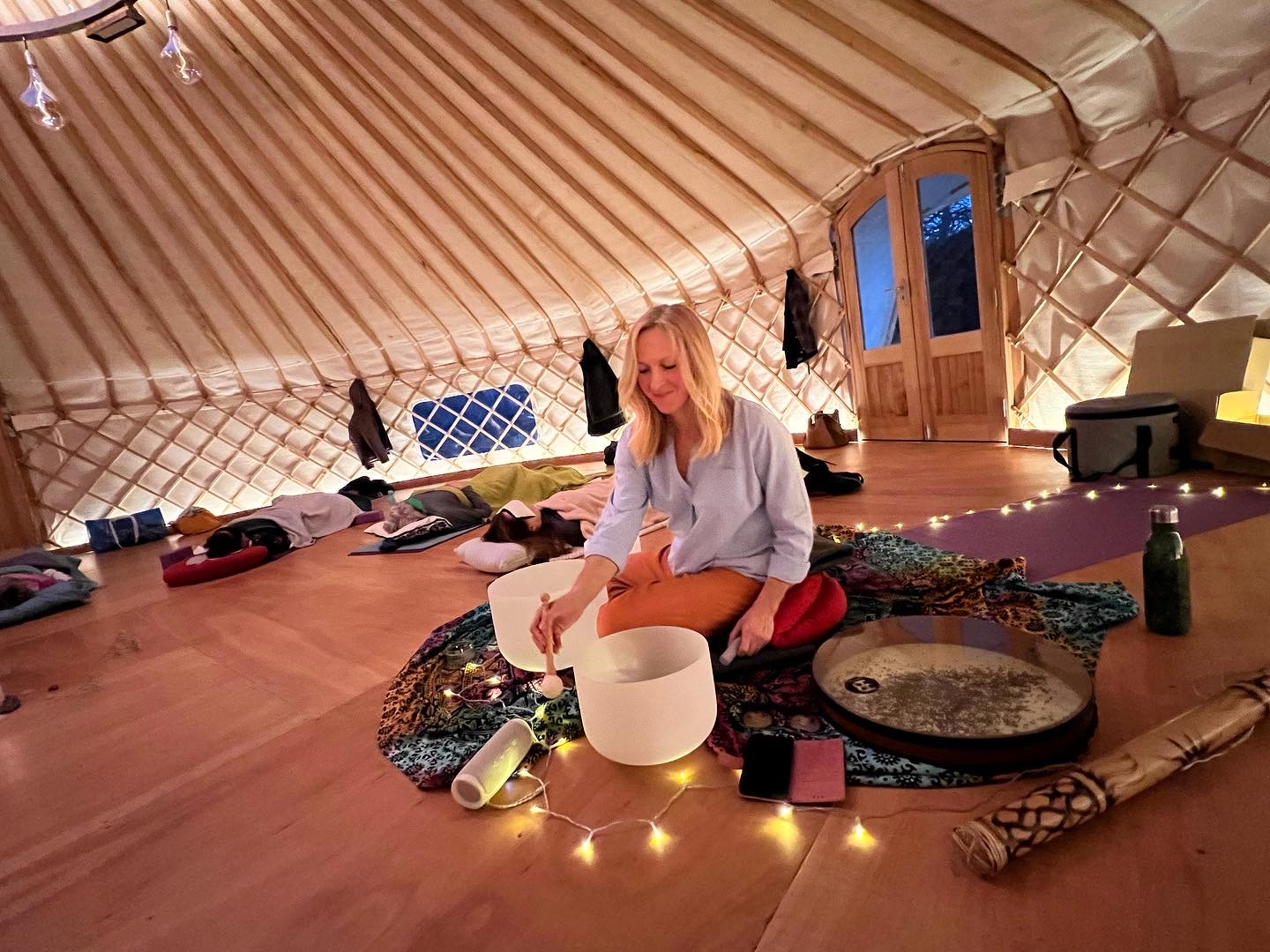 Magda from Serenity Yoga playing crystal singing bowls during a healing sound bath in the Yurt at Tofte Manor