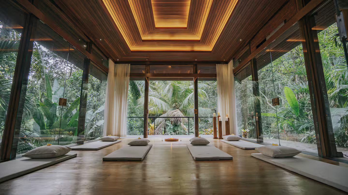 Open-air yoga shala at Dwa Chandra with wooden floors and tropical jungle views
