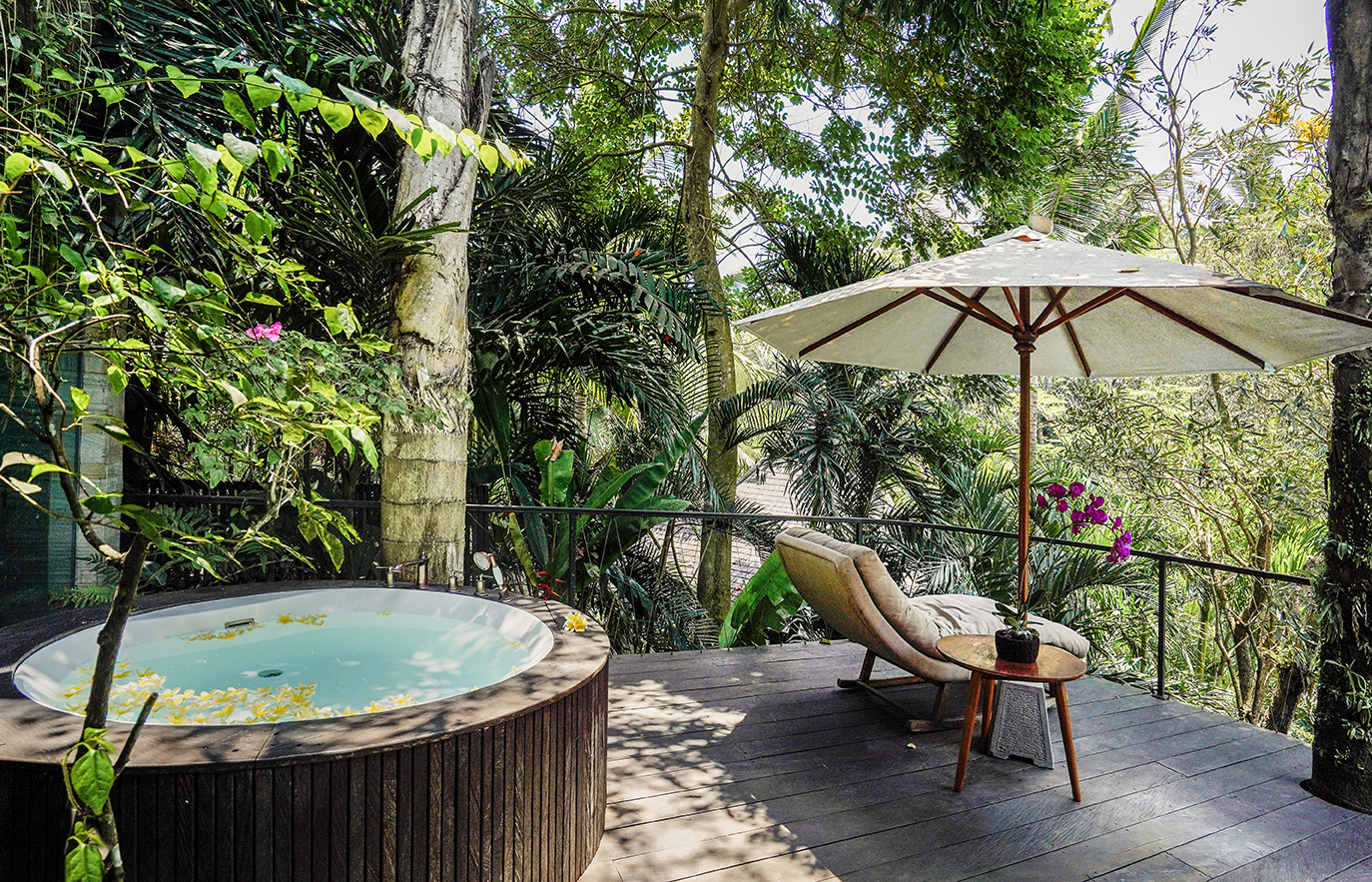 A private deck at Dwa Chandra with jungle hot tub, lounger and orchids