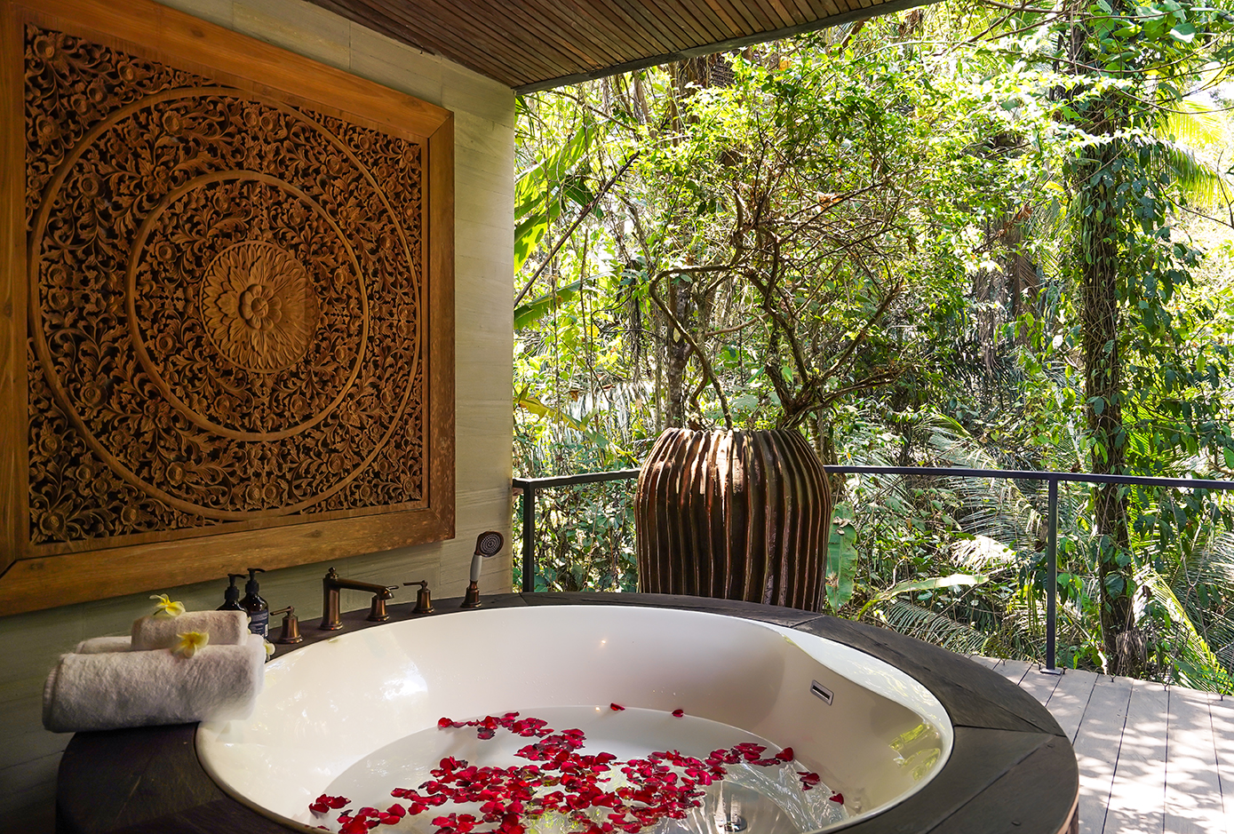 Outdoor bath with rose petals overlooking Balinese jungle