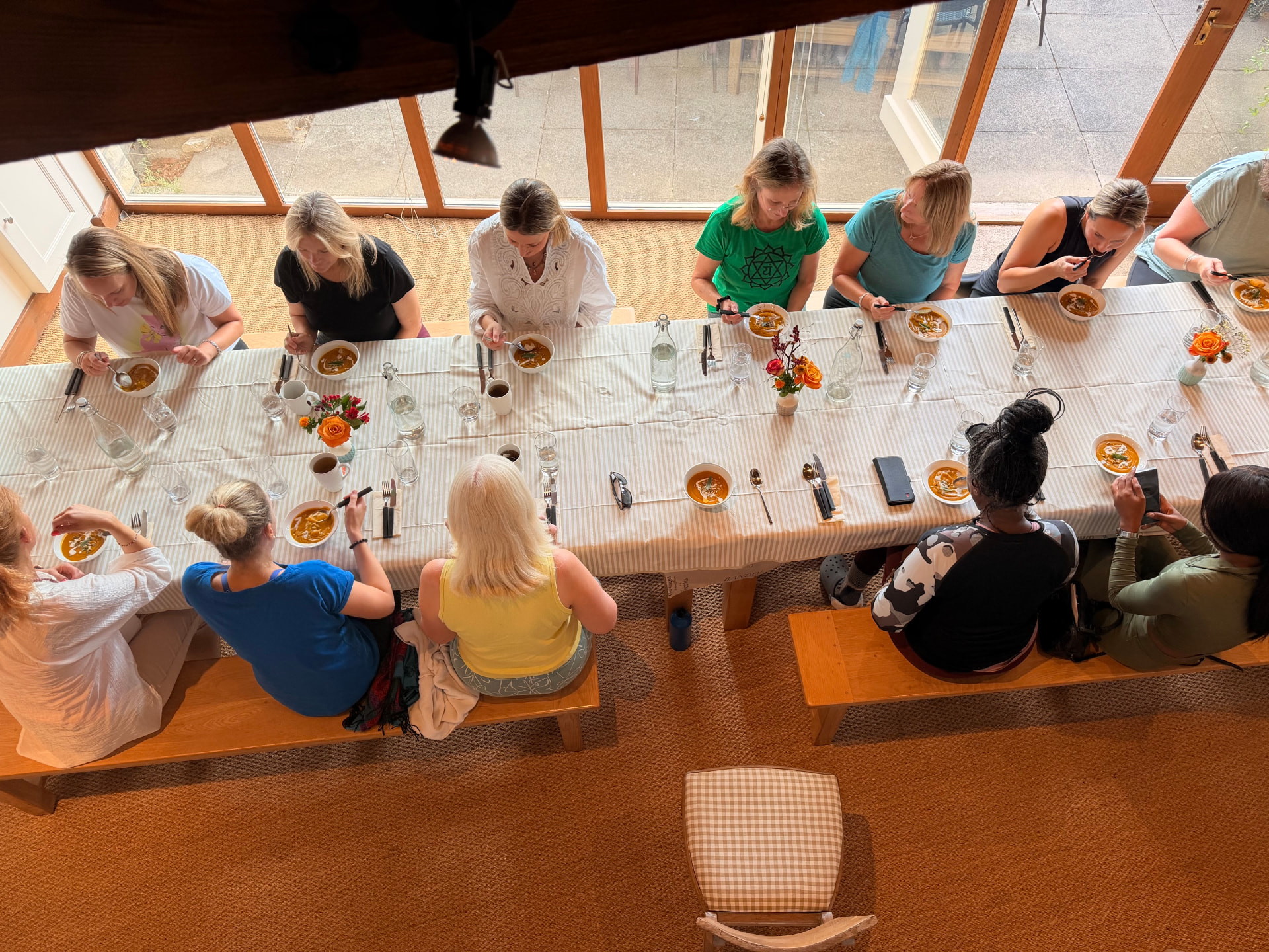 Women sharing bowls of roasted squash soup around a long table at Tofte Manor