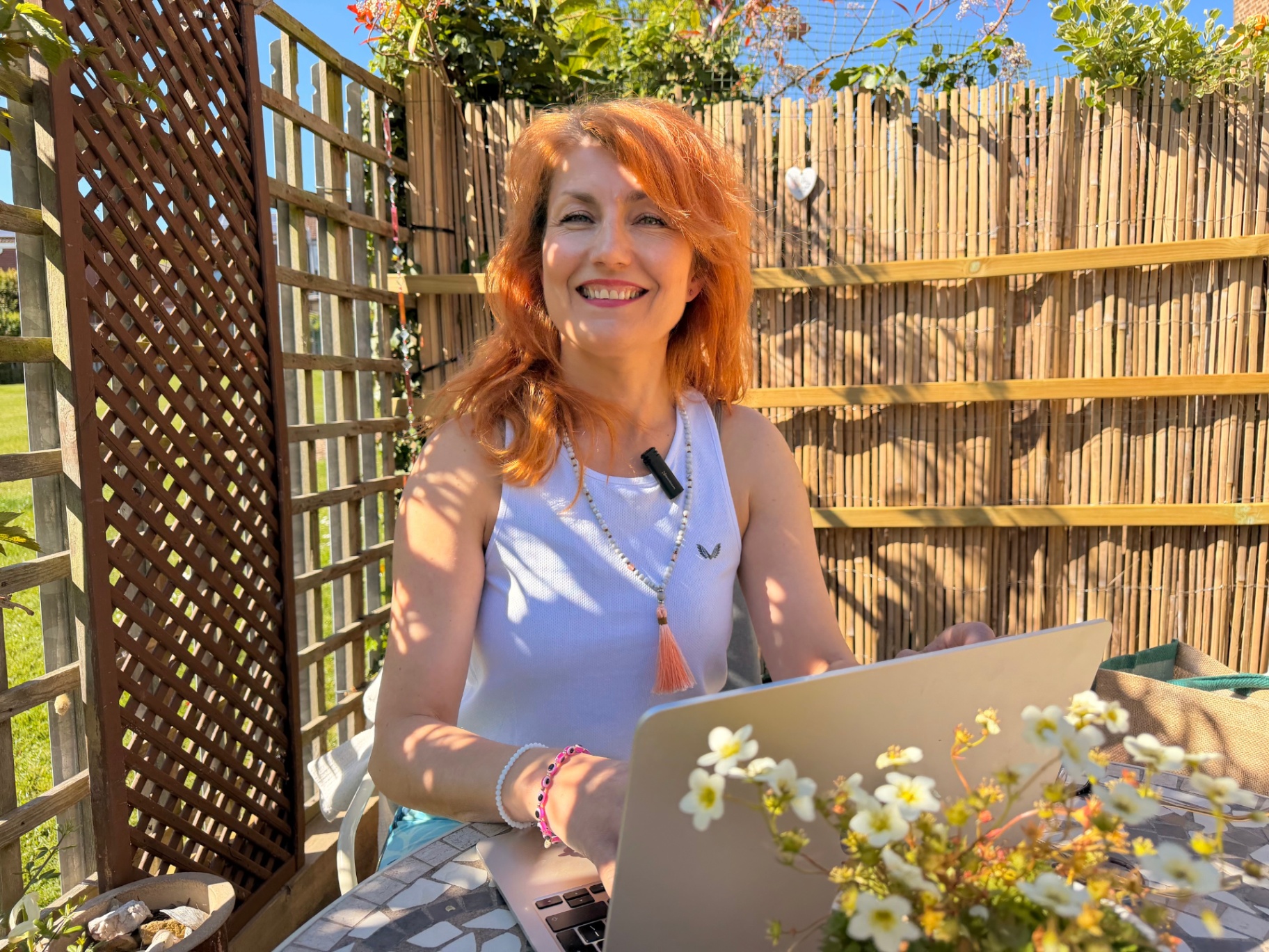 Julia working on her laptop in a sunny garden